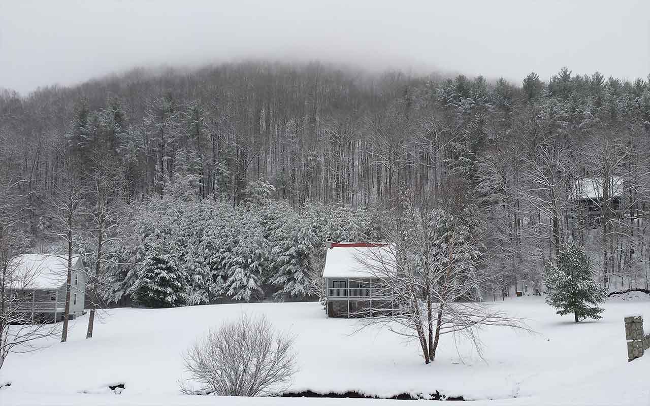 Snow-covered cabins and forested mountain in winter near Blairsville, GA